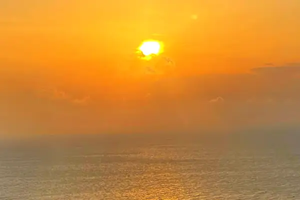 現地から望む夕陽の写真